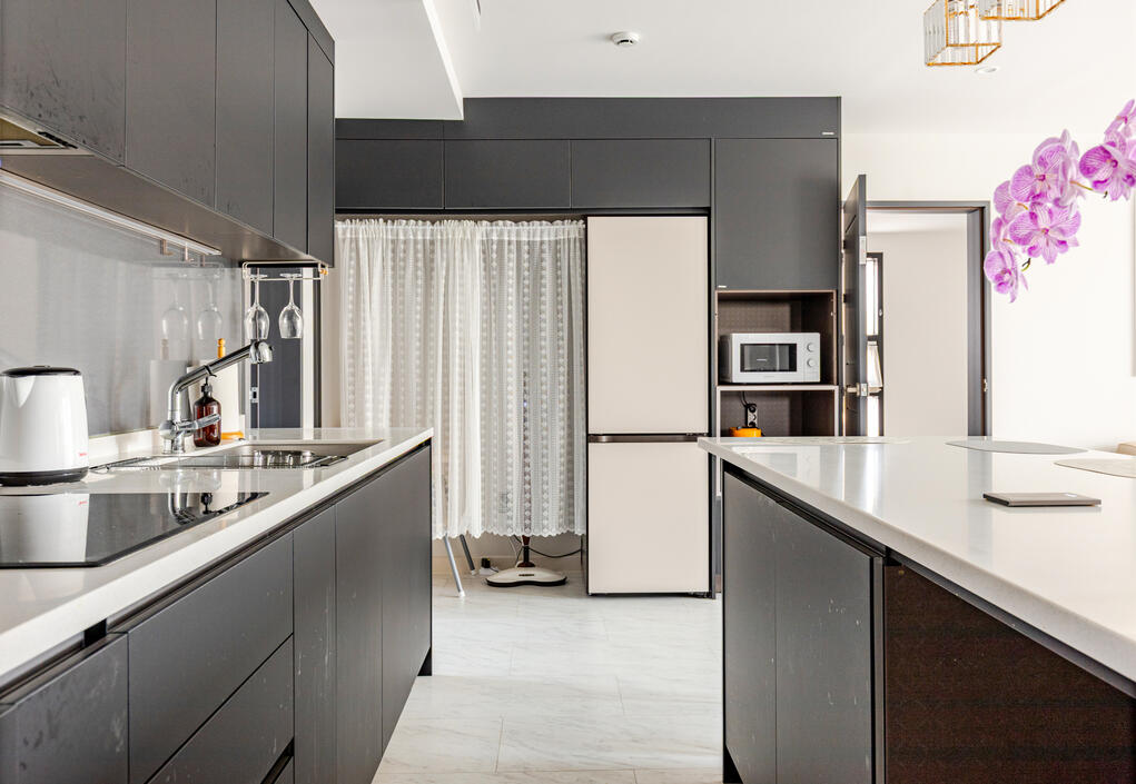 View from the entrance into the kitchen. Behind the white curtain are baby tub, highchair and a cordless floor cleaner View from the entrance into the kitchen. Behind the white curtain are baby tub, highchair and a cordless floor cleaner