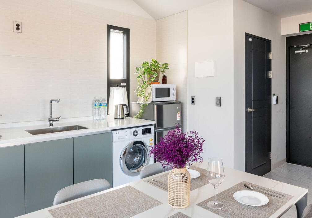 Washer and refrigerator. The closed door is the bathroom Washer and refrigerator. The closed door is the bathroom